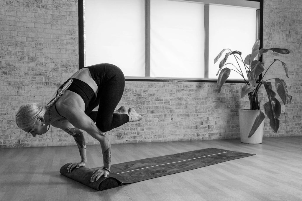 Diana performing a crouched handstand on the UTKATAMAT, showcasing strength, balance, and precise control in her pose.