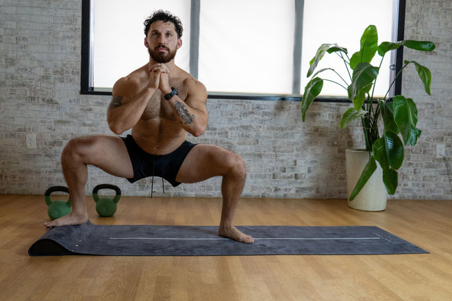 Jeremy demonstrating a powerful sumo squat on the UTKATAMAT yoga mat, highlighting strength, stability, and proper form.